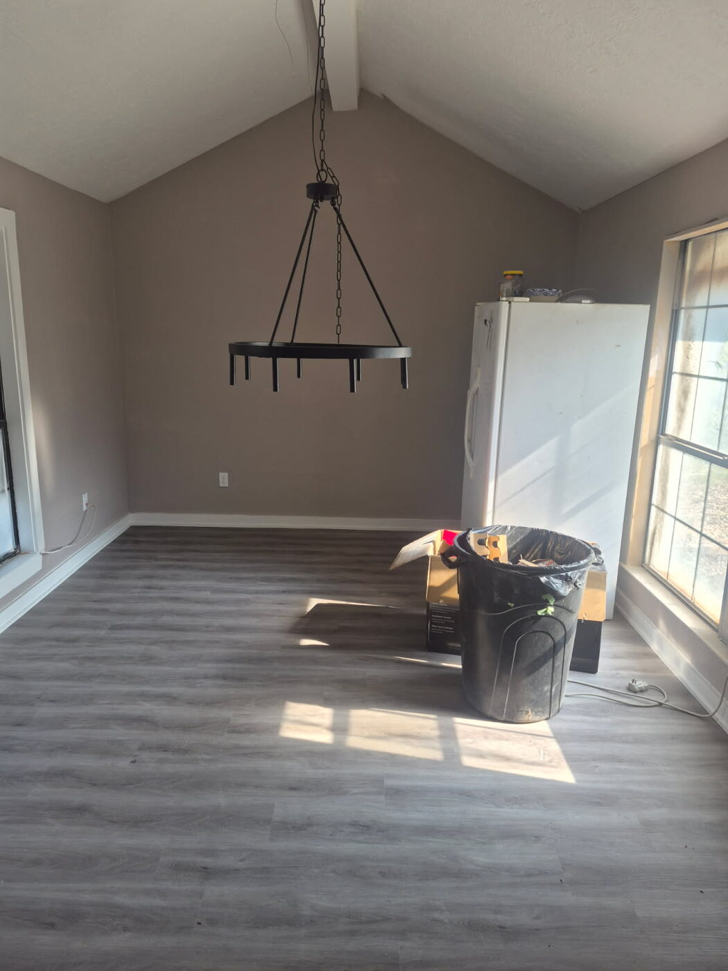 Dining area with new gray plank flooring and vaulted ceiling