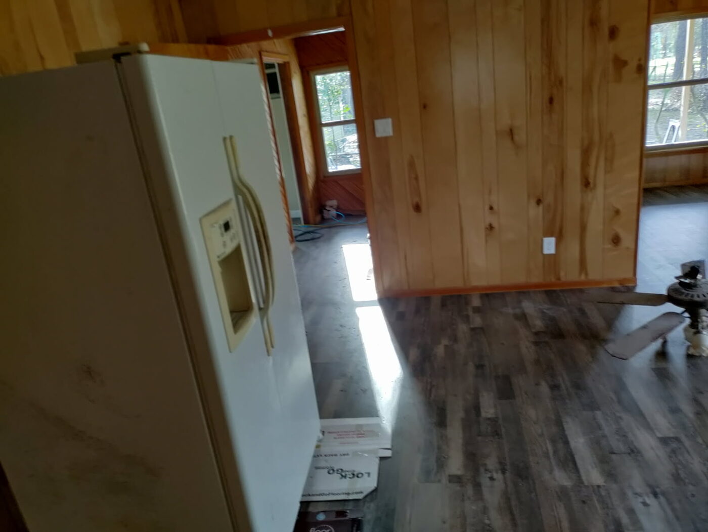 Wood-paneled room with new plank flooring