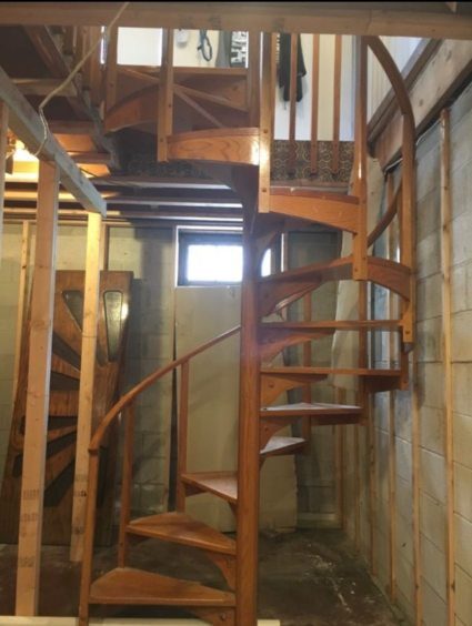 Wooden spiral staircase inside an unfinished framed space